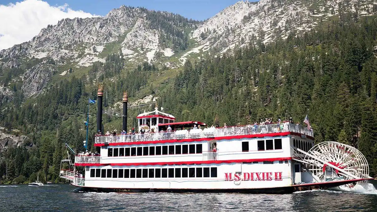 The M.S. Dixie II paddle-wheeler with its red stern wheel on Lake Tahoe below granite peaks