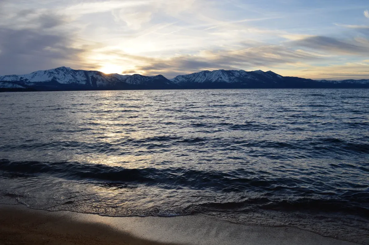 Waves on Lakeside Beach in South Lake Tahoe at a winter sunset with snow on the far mountains