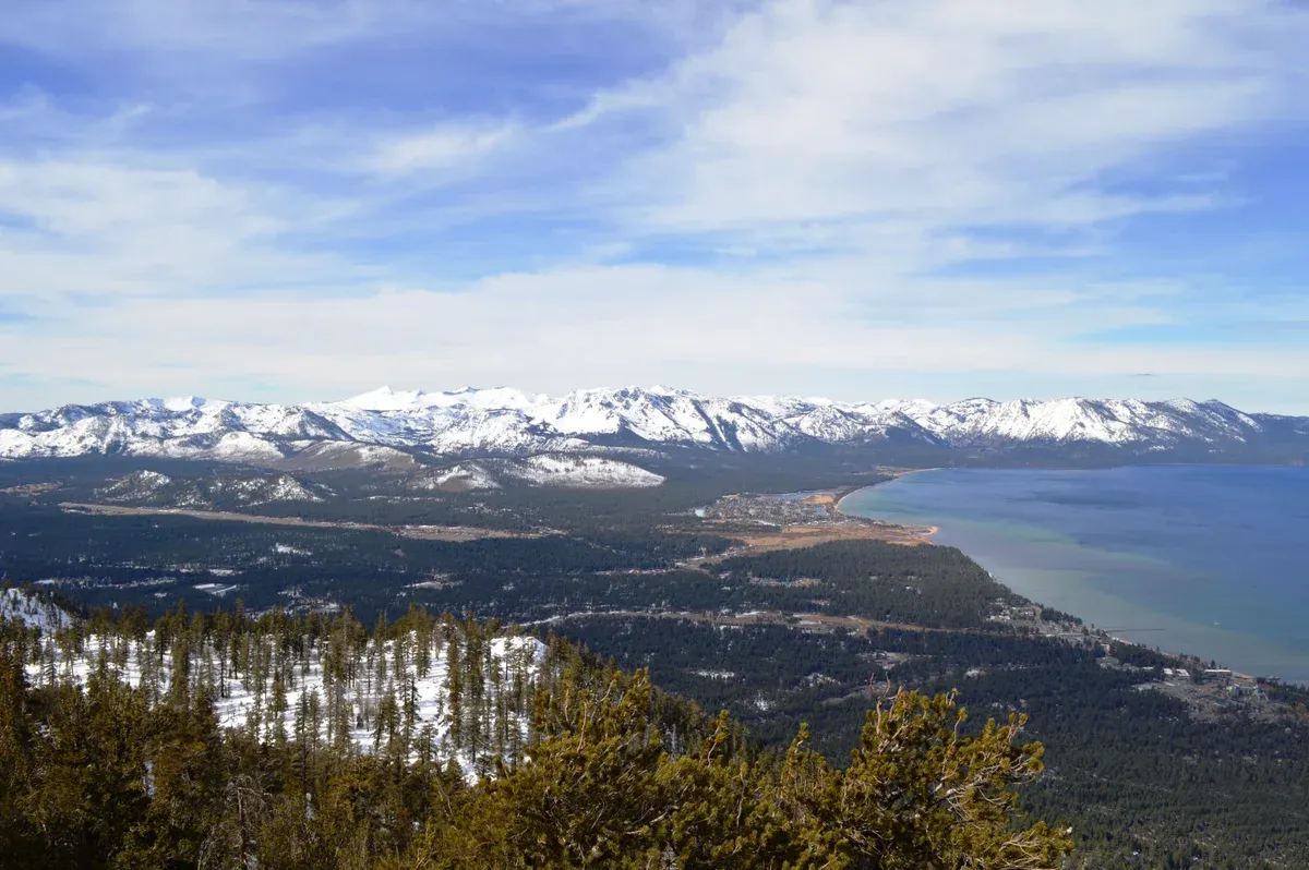 South Lake Tahoe and the south shore seen from high above, with snow on the far mountains